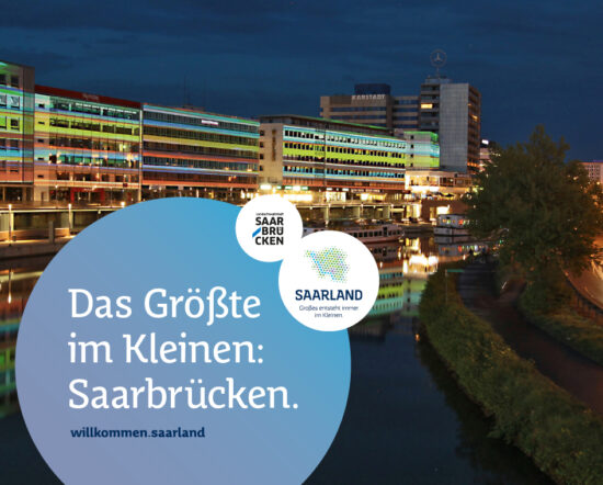 Eine Nachtansicht von Saarbrückens modernen, beleuchteten Ufergebäuden, die sich im Wasser spiegeln; der Text lautet: