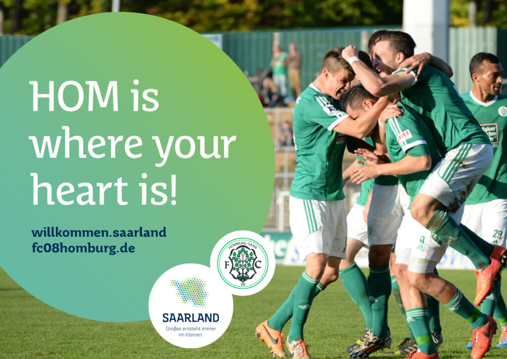 Eine Gruppe von Fußballspielern in grünen Trikots feiert auf dem Spielfeld. Der Text auf dem Bild lautet: "HOM is where your heart is!" mit Logos und Website-Adressen für das Saarland, den FC 08 Homburg und Saarland Marketing - Deutschlands Hidden Champion.